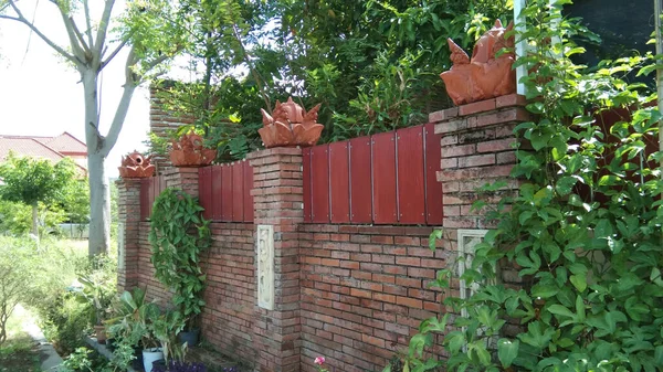 Majapahit kraliyet temalı çit. Çitin sonunda tuğlalar ve taç süslemeleri var.
