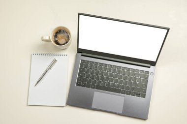Beyaz ekranlı bilgisayar bilgisayarı, not defteri, kahve fincanı ve beyaz arka planda kopyalama alanı. Boş ekranlı bir dizüstü bilgisayar ya da bilgisayar