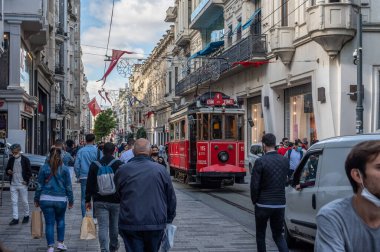 İSTANBUL, TURKEY - 12 Ekim 2021: İstanbul 'da Kalabalık İstiklal Caddesi. İstanbul 'da eski bir tramvay. Meşhur Istiklal caddesinde nostaljik kırmızı tramvay