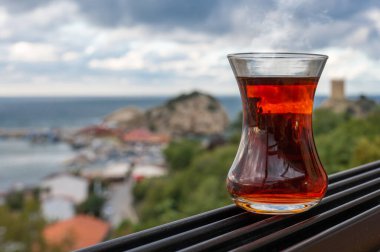 Kadın eli üzerinde çay fincanı armuda, İstanbul 'un arka planında geleneksel Türk çayı, Sile şehir manzarası. Bir bardak Armuda ve çay.