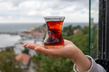 Kadın eli üzerinde çay fincanı armuda geleneksel Türk çayı Türk kırmızı aromatik çayı geleneksel otantik cam fincanda - armudu