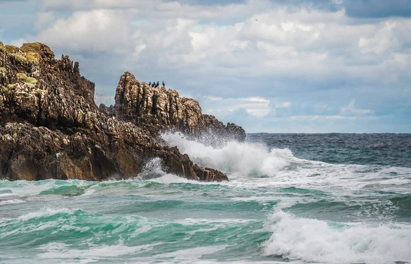 Океанські Водні Бризки Скелястому Пляжі Міцними Скелями Морем Хмарами Морська — стокове фото