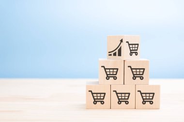 Satış simgeleriyle ahşap küp piramidi. Satış hacmi artışı iş büyütme kavramını oluşturur. Simge grafiği ve alışveriş arabası sembolüyle satış piramidinin en üst küpü.