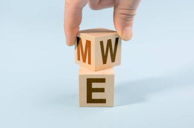 Benimle birlikte ahşap küpü çevir ya da mavi arka planda kalalım. Takım çalışması konsepti. El zarları çevirir ve ME kelimesini 