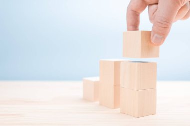 İşadamı elini kapat ve merdiven olarak boş tahta küpü yerleştir. İş büyüme süreci için merdiven kariyer yolu kavramı. Ahşap blokları merdiven olarak dizmek için el düzenlemesi