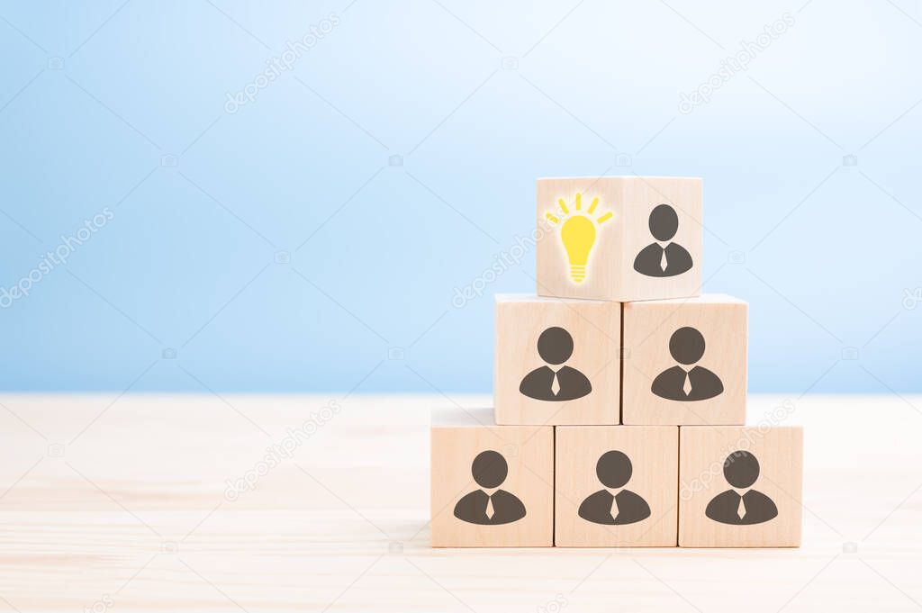 Leader with idea and innovation, flips cube with icon light bulb and human symbol. corporate hierarchy and new idea concept. blue background. copy space