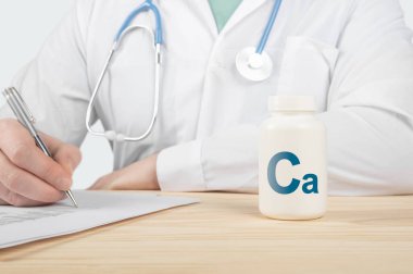 Kemik insan sağlığı için kalsiyum takviyesi. Doktor kalsiyum almayı öneriyor. Doktor kalsiyumun faydalarından bahsediyor. İnsanlar için temel vitamin ve mineraller. Kalsiyum Sağlık Konsepti.