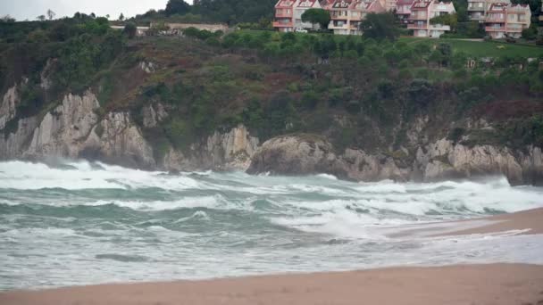 파도가해 바위들에 부딪쳐 폭발적으로 솟구쳐 오르고 있습니다 해변으로 밀려드는 — 비디오