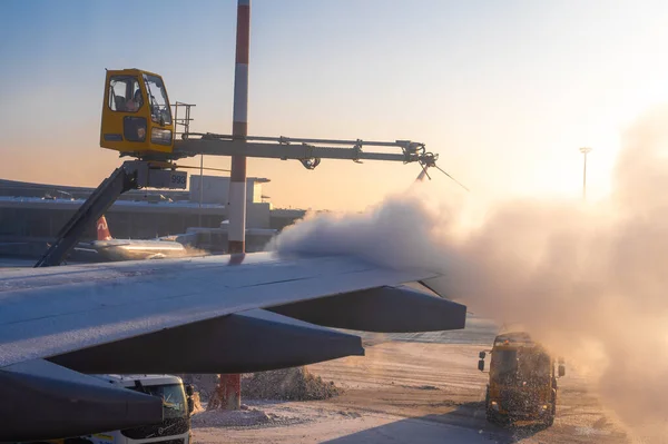 2022年1月12日 俄罗斯莫斯科 Sheremetyevo国际机场 除冰的飞机翼 冬季日出时在机场向机翼后部喷洒防冻液的过程 — 图库照片