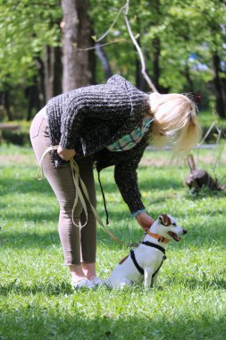 Parkta köpeği olan genç bir kadın.