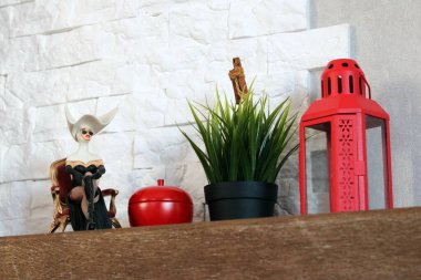 Eski ahşap masa, bir mum, bir kız heykeli ve çimen.