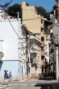 İnsanlar sokaktaki eski binalara doğru yürüyorlar.