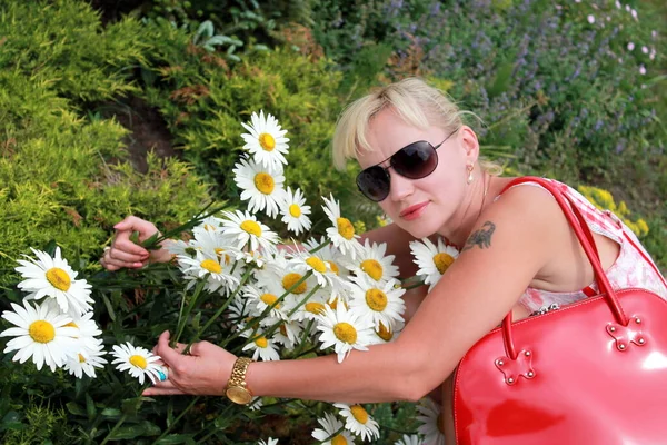 beautiful young woman with flowers in the field