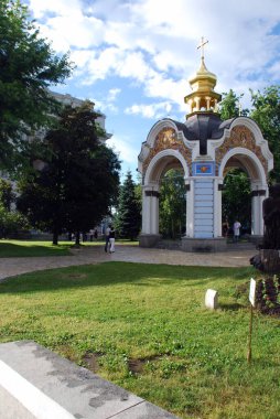 Arkasında yeşil bitkiler olan ortodoks kilisesi.