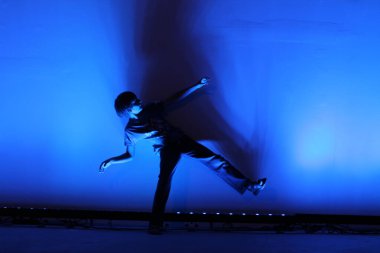 Genç adam stüdyoda dans ediyor.