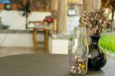 Vazolar ve kurumuş çiçekler masaya konur..