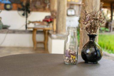 Vazolar ve kurumuş çiçekler masaya konur..