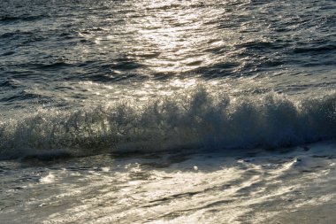 Atlantik Okyanusu 'nun küçük bir dalgası Gün doğumunun ışıltısıyla