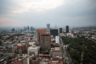 Torre Latinoamerika 'nın çatısından gün batımında bulutlu bir günde Mexico City manzarası