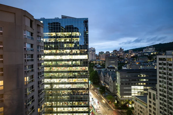 View of the Downtown Montreal skyline at night taken from above. The lights on the buildings are starting to turn on.