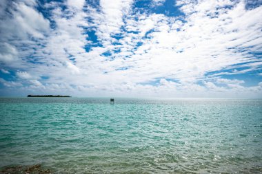 Florida Keys 'ten okyanus manzarası. Su bir Türk rengidir ve gökyüzü mavi bulutlar görünür. Bu fotoğraf çekildiğinde hava sıcaktı. Rüzgar suda dalgalar yaratır..
