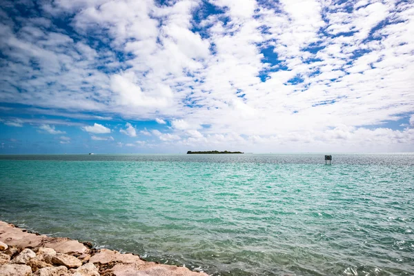 フロリダ キーからの海の眺め 水はターコイズ色で 空は青い雲が現れます この写真を撮ると天気は暖かかった 風は水の中に波を作り出す — ストック写真