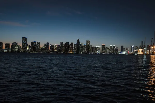 佛罗里达州迈阿密市中心的天际线在夜间从一条位于迈米南部海峡水域的船上被拍下 — 图库照片
