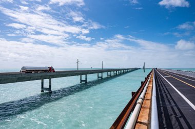 Florida Keys 'teki Seven Mile Köprüsü, Florida' daki Bahia Honda Key ile Marathon anahtarını birbirine bağlayan ve Florida Eyalet Yolu A1A 'yı içeren iki şeritli bir yol. Sea View Seven Mile Köprüsü parkından alındı. Su turkuaz rengidir.