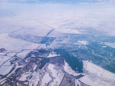 Kışın, bulutlu bir günde, yerde karla Michigan üzerinde uçmak. Kar ve buz Detroit 'in güneybatısındaki banliyölerde görülebilir. Uçaktan alınmış..