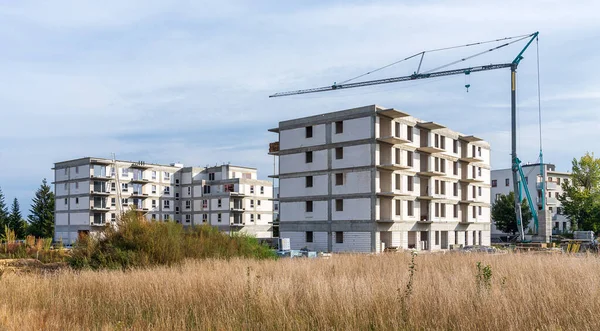 Construction of a housing estate with white walls. Tower crane. Tymbark, Poland.