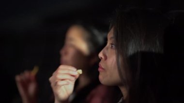 Sinemada film izleyen genç kadınlar.