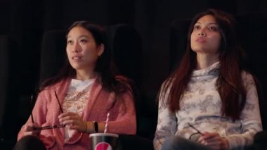 Genç kadınlar sinemada film izlemekten hoşlanır.