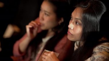 Sinemadaki arkadaşlar film izlerken eğlenirler.