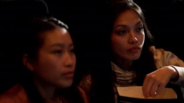 Sinemadaki arkadaşlar film izlerken eğlenirler.