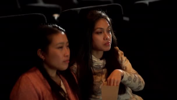 Mujeres jóvenes en un cine viendo una película — Vídeos de Stock