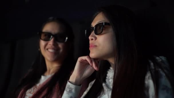 Молодые женщины в кино смотрят кино — стоковое видео