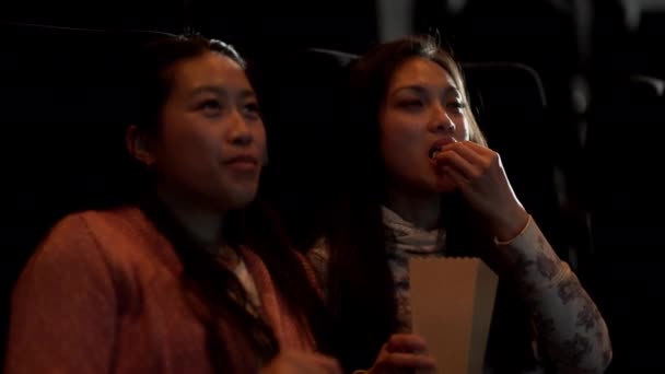 Jovens mulheres em um cinema assistindo um filme — Vídeo de Stock