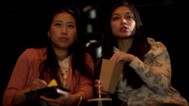 年轻女人喜欢在电影院看电影 吃爆米花和玉米片 — 图库视频影像