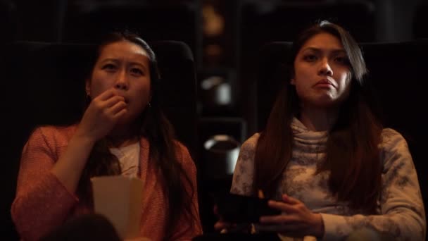 Молодые Женщины Кинотеатре Смотрят Кино Едят Попкорн — стоковое видео