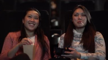 Sinema salonundaki izleyiciler büyük bir sinema izliyorlar.