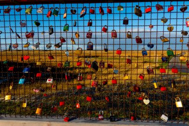 Kuzey Frizya 'da Wadden Denizi' ndeki bir tahtaya bağlı aşk kilitleri. Seyahat fotoğrafçılığı.