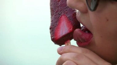 Genç kadın dondurmayı yalıyor. Yakın çekim.