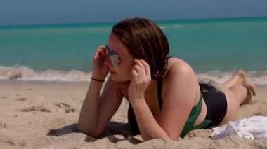 Genç mutlu kadın güneşli bir günde Miami Plajı 'nda dinleniyor.