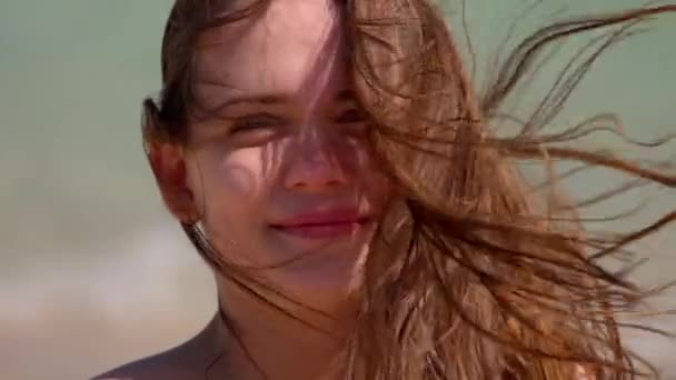 Κοντινό πλάνο μιας νεαρής γυναίκας σε μια θυελλώδη μέρα στην παραλία — Αρχείο Βίντεο