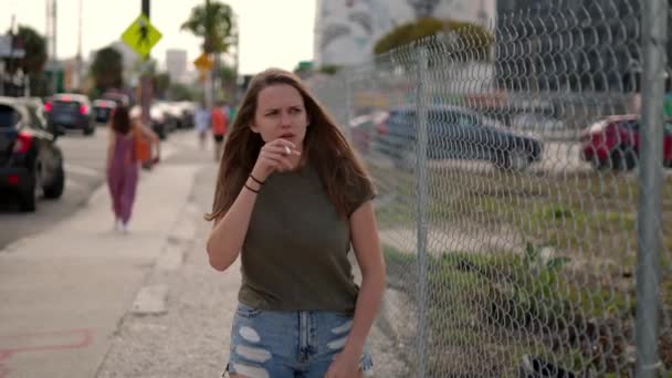 Jonge vrouw verdwaald in gedachten rookt een sigaret — Stockvideo