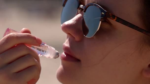 Young woman applies Lip gloss - close up shot — Stock Video