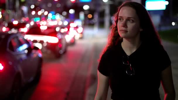 Giovane donna che cammina lungo la strada di notte — Video Stock