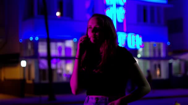 Kleurrijke Ocean Drive op Miami Beach 's nachts - Jonge vrouw neemt een telefoontje onder de neon lichten — Stockvideo