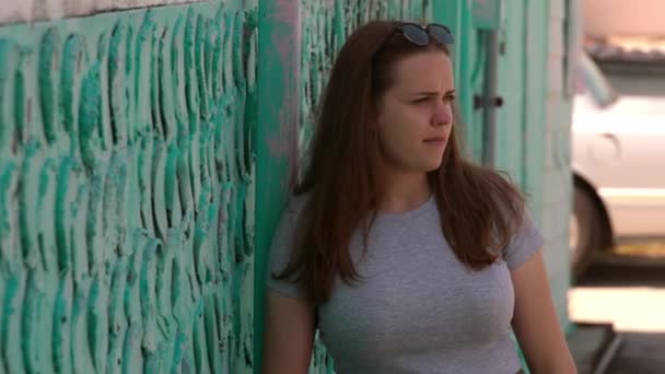 Portrétní záběr mladé hezké ženy opírající se v létě o zeď — Stock video
