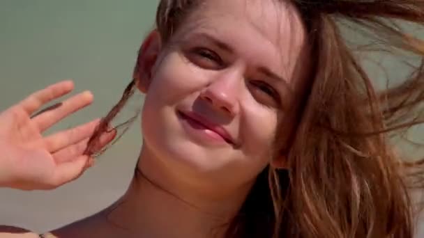 Gros plan d'une jeune femme par une journée venteuse à la plage — Video